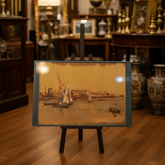Framed artwork of sailboats on a blue chair